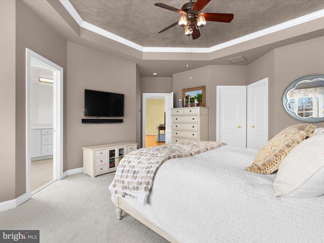 carpeted bedroom featuring ceiling fan, crown molding, and a raised ceiling