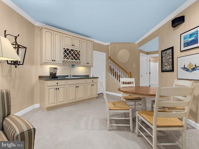 dining area with light colored carpet, ornamental molding, and wet bar