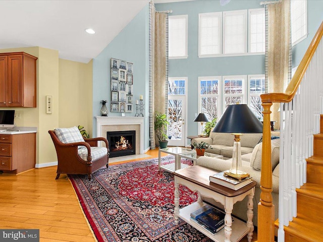 sitting room with a towering ceiling and light hardwood / wood-style flooring