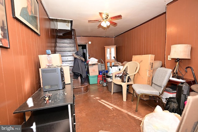 home office with wooden walls, ceiling fan, and ornamental molding