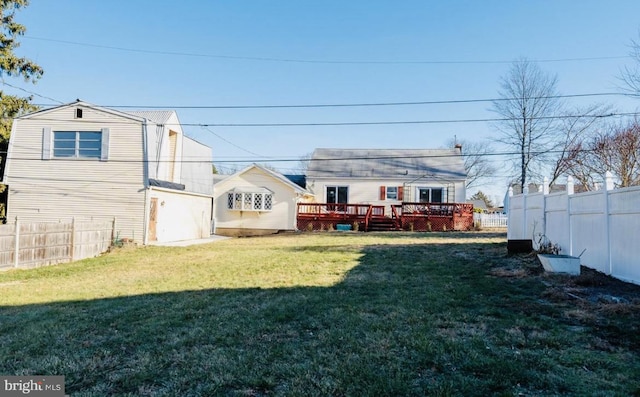 rear view of property with a lawn and a wooden deck