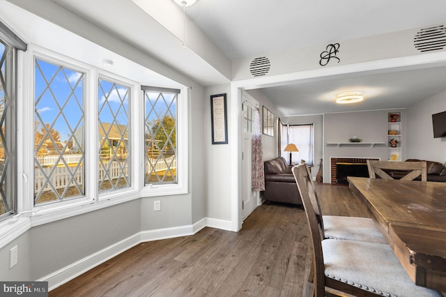 dining space with hardwood / wood-style flooring and a fireplace