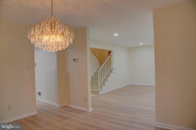 interior space featuring light wood-type flooring and an inviting chandelier