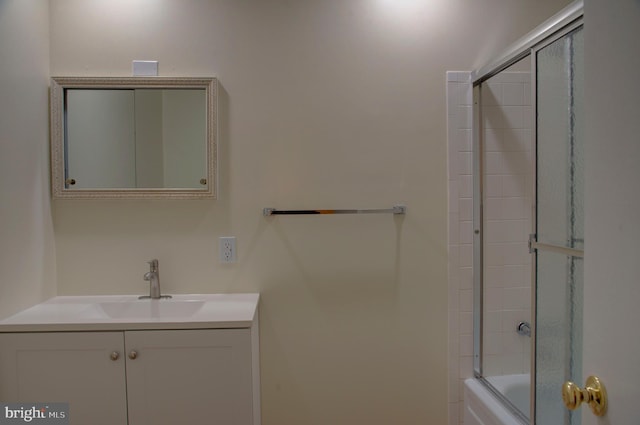 bathroom featuring combined bath / shower with glass door and vanity