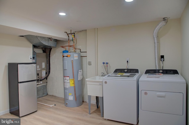 laundry area featuring independent washer and dryer, light hardwood / wood-style floors, heating unit, and water heater