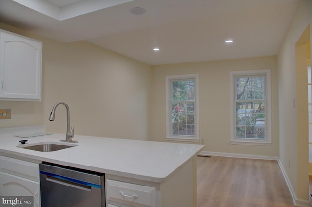 kitchen with stainless steel dishwasher, light hardwood / wood-style floors, white cabinetry, and sink