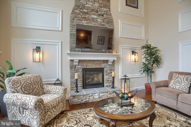 living room featuring hardwood / wood-style flooring and a stone fireplace