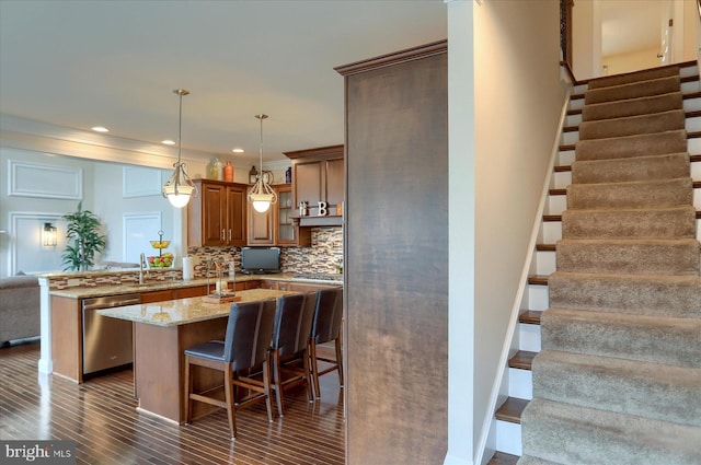 kitchen featuring a breakfast bar, decorative backsplash, light stone countertops, kitchen peninsula, and stainless steel appliances