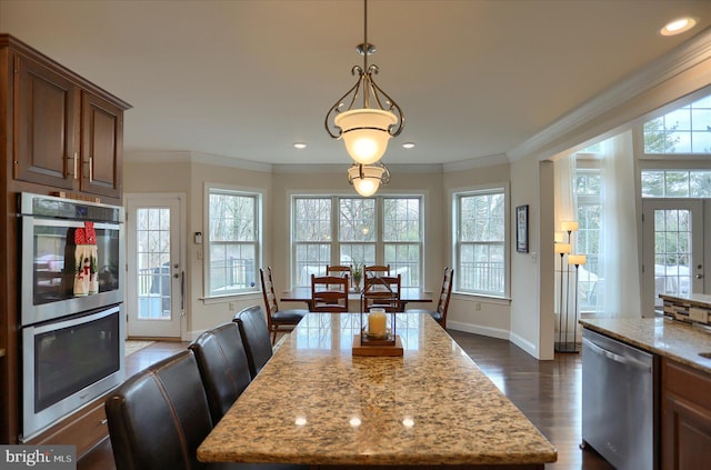 dining room featuring crown molding, a healthy amount of sunlight, and dark hardwood / wood-style floors