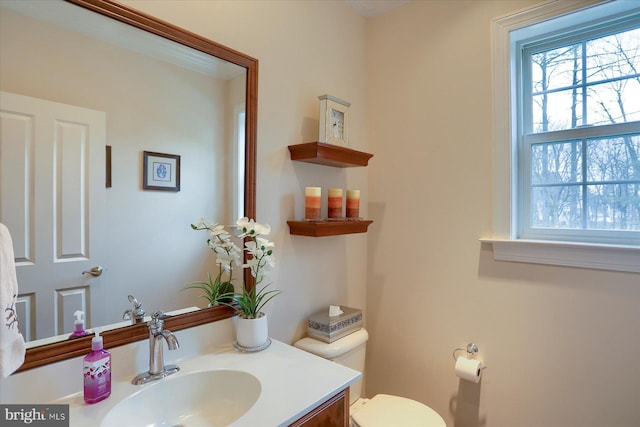 bathroom featuring vanity, toilet, and a wealth of natural light