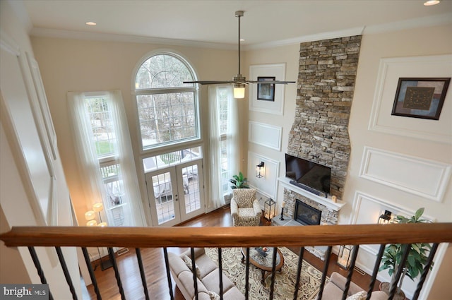 living room with ceiling fan, french doors, ornamental molding, a fireplace, and hardwood / wood-style flooring