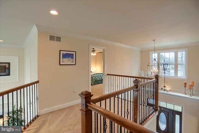 hallway with light colored carpet, an inviting chandelier, and ornamental molding