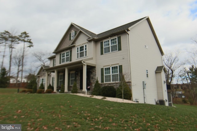 view of front of house featuring cooling unit and a front yard