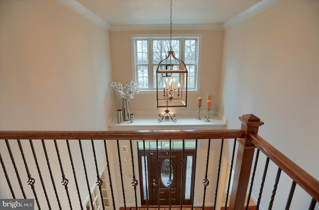 entrance foyer with crown molding and an inviting chandelier