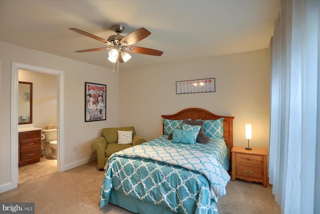 bedroom featuring ceiling fan, ensuite bathroom, and light carpet