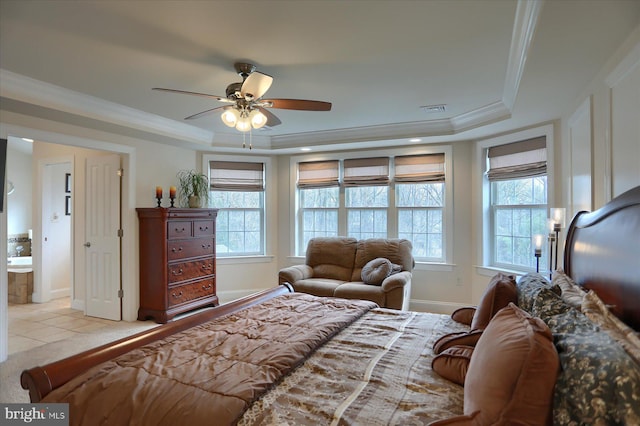 bedroom with a tray ceiling, ensuite bath, ceiling fan, and ornamental molding