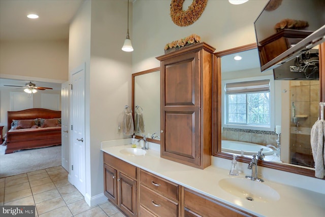 bathroom featuring tile patterned flooring, vanity, a tub to relax in, and ceiling fan