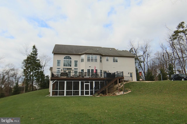 rear view of property featuring a yard, a wooden deck, and a sunroom