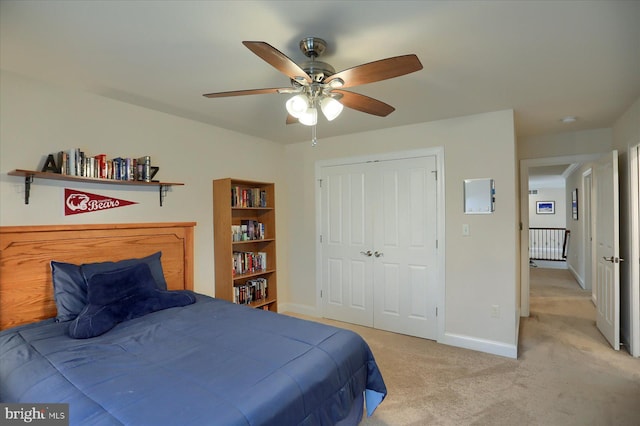 bedroom featuring ceiling fan, light colored carpet, and a closet