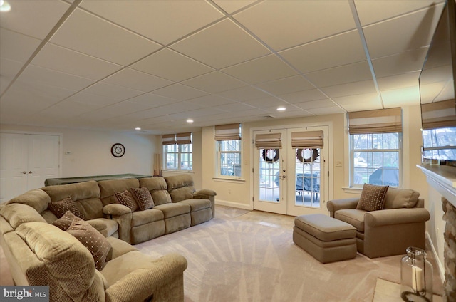 carpeted living room featuring french doors and a drop ceiling