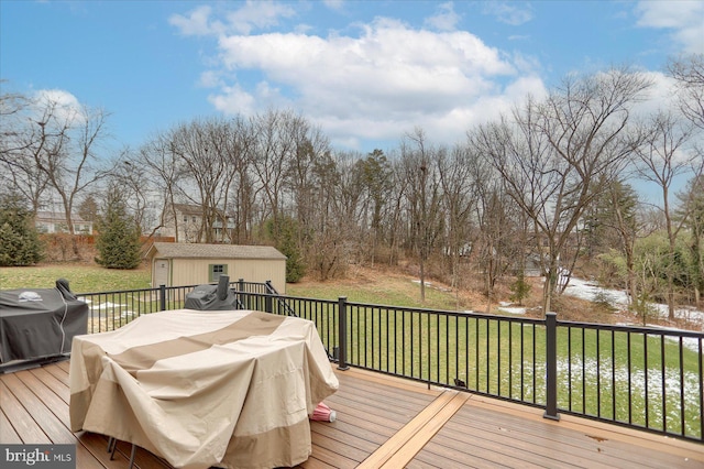 wooden deck with area for grilling, a storage shed, and a lawn