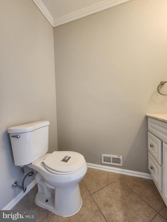 bathroom with tile patterned flooring, vanity, toilet, and crown molding