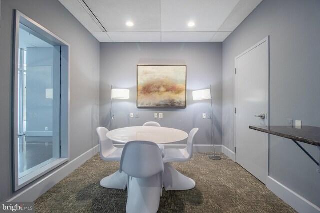 dining space featuring a paneled ceiling and carpet flooring