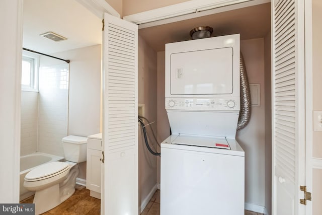 washroom featuring stacked washer / drying machine