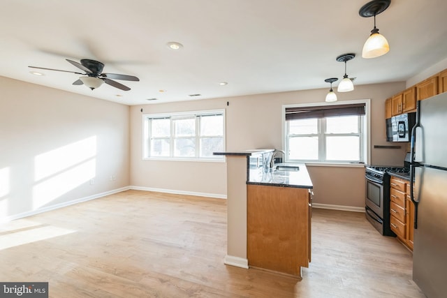 kitchen with black appliances, decorative light fixtures, light hardwood / wood-style floors, and ceiling fan