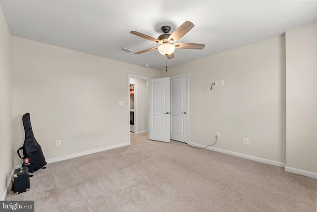 empty room with ceiling fan and light carpet