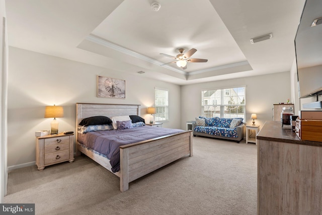 carpeted bedroom featuring a raised ceiling, ornamental molding, and ceiling fan