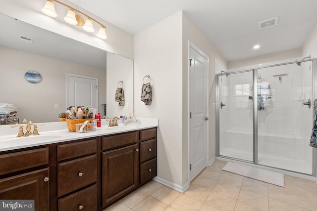 bathroom with vanity, a shower with shower door, and tile patterned flooring