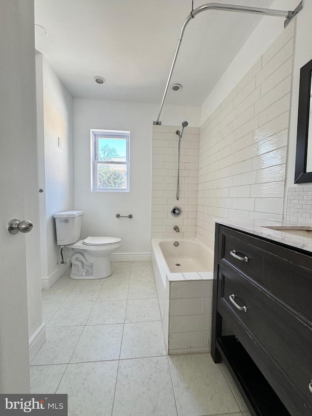 full bathroom featuring tile patterned flooring, vanity, tiled shower / bath combo, and toilet