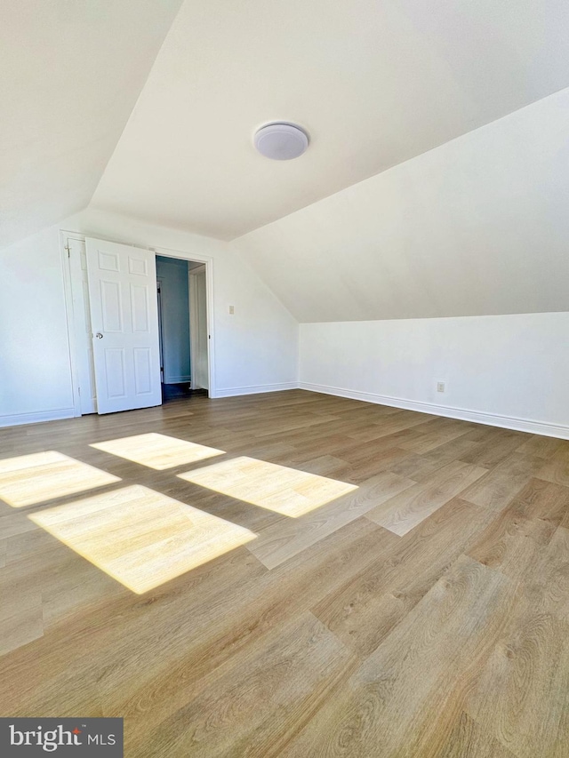 bonus room featuring lofted ceiling and light wood-type flooring