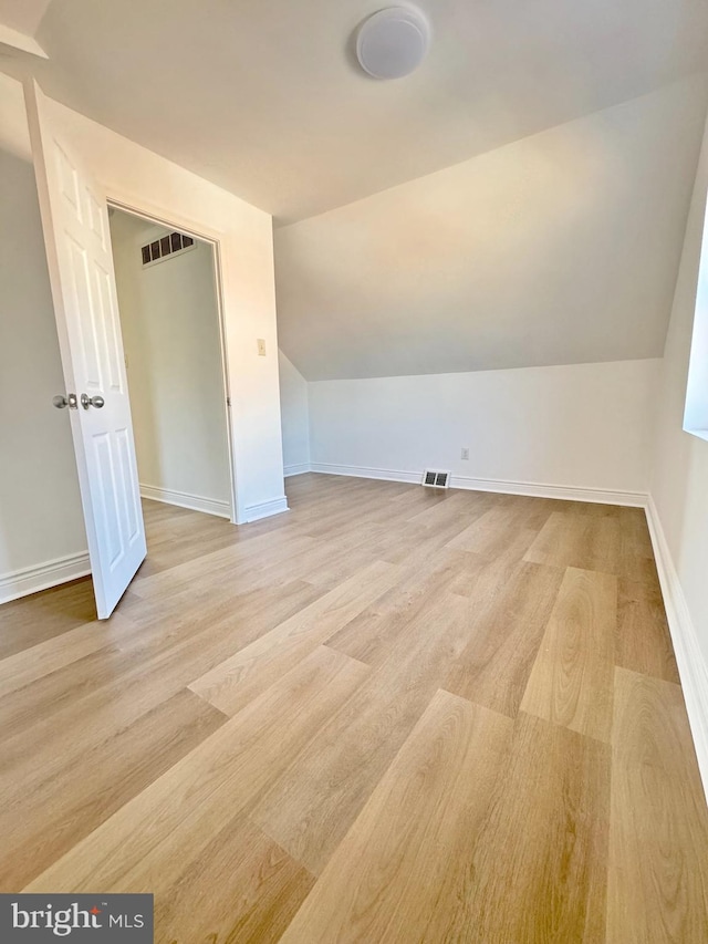 bonus room with light hardwood / wood-style flooring and lofted ceiling