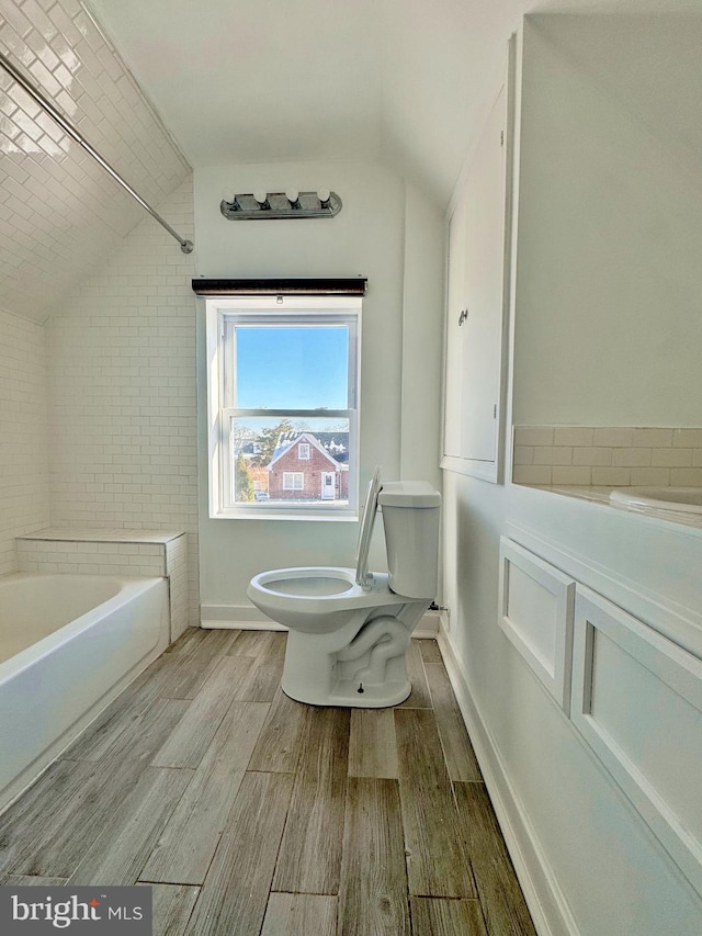 bathroom featuring tiled shower / bath combo and toilet