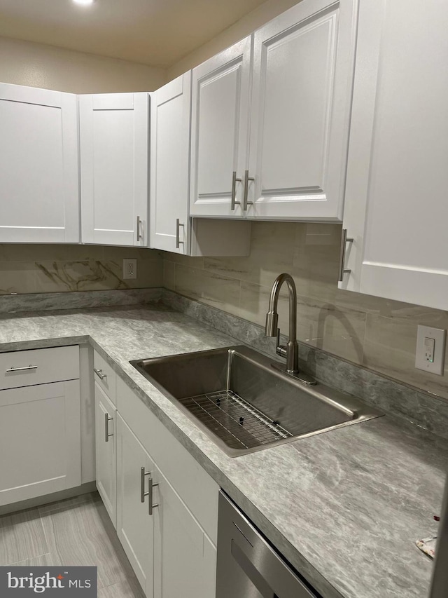 kitchen with white cabinets, decorative backsplash, and sink