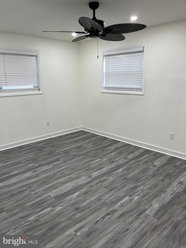 spare room featuring ceiling fan and dark wood-type flooring