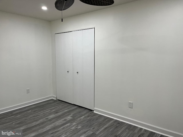 unfurnished bedroom featuring dark hardwood / wood-style flooring and a closet