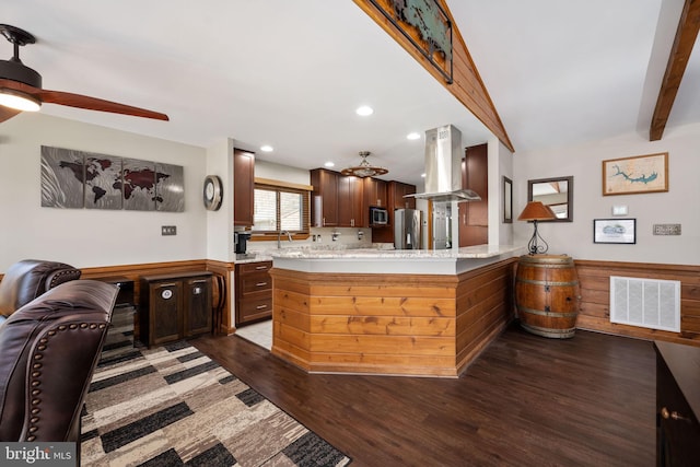 kitchen with dark wood-type flooring, ceiling fan, range hood, kitchen peninsula, and stainless steel appliances