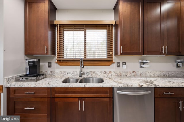 kitchen featuring dishwasher, sink, and light stone counters