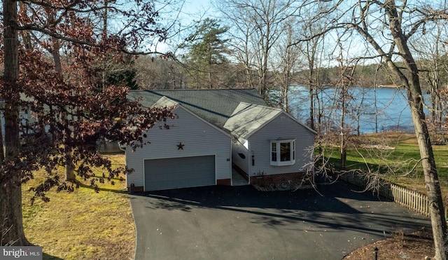 view of front facade featuring a garage and a water view