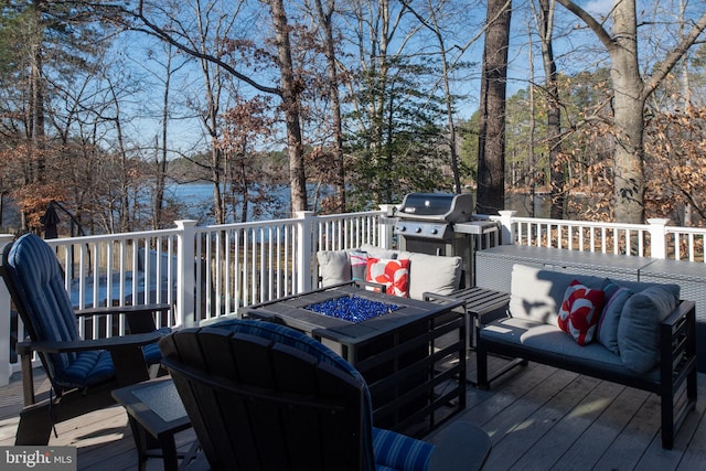 wooden deck featuring grilling area and an outdoor living space with a fire pit