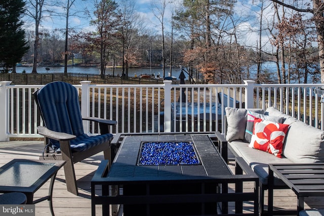 wooden deck with a water view and an outdoor living space with a fire pit