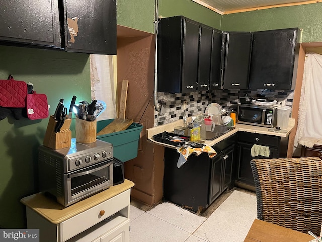 kitchen with light tile patterned floors, tasteful backsplash, and sink