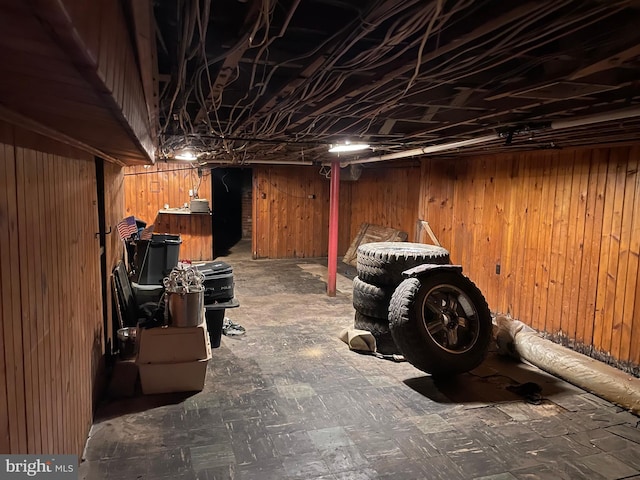 basement featuring wood walls