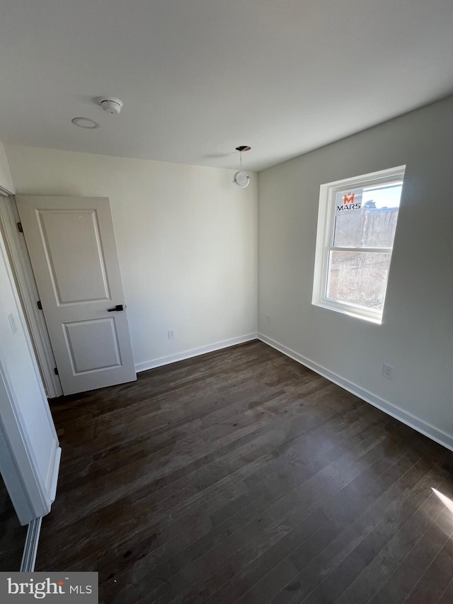 interior space featuring dark wood-style flooring and baseboards