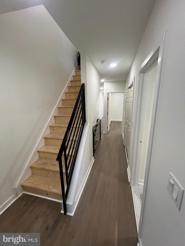 stairs with hardwood / wood-style floors and baseboards