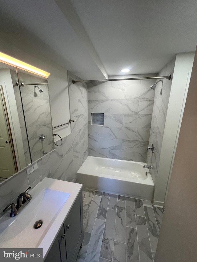 bathroom with marble finish floor, shower / bathing tub combination, and vanity