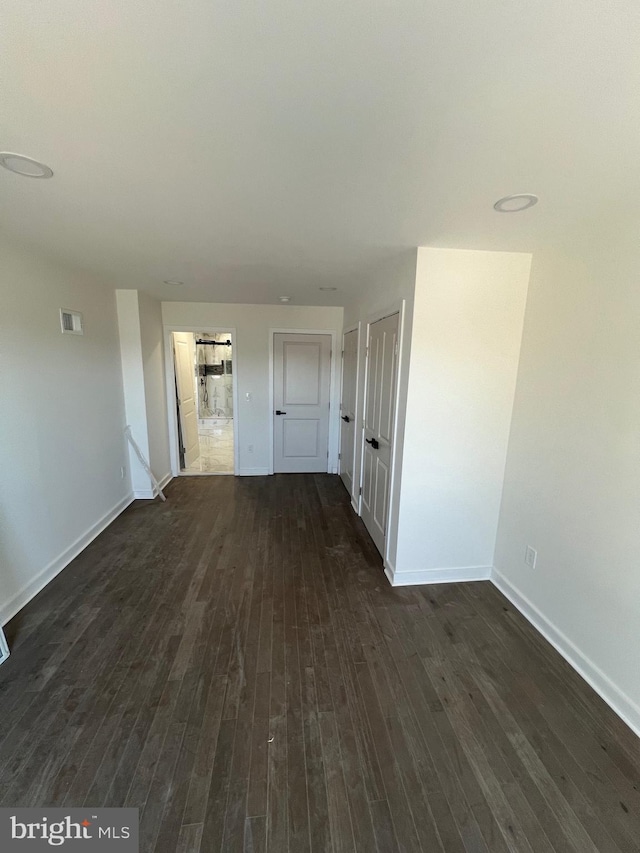 interior space featuring visible vents, dark wood finished floors, and baseboards